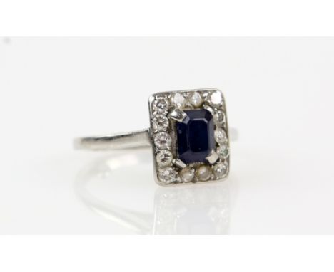 Sapphire &amp; diamond cluster ring, rectangular step cut sapphire, round brilliant cut diamond surround, mounted in white me