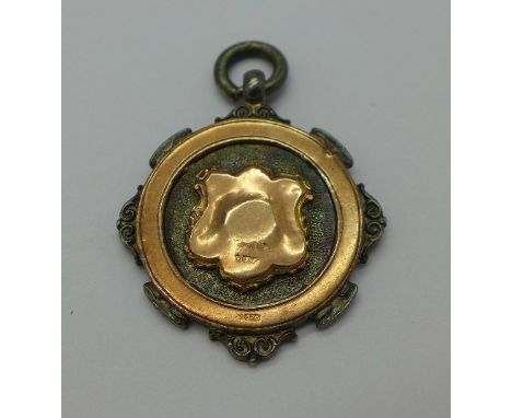 A silver fob with 9ct gold hallmarked applied decoration