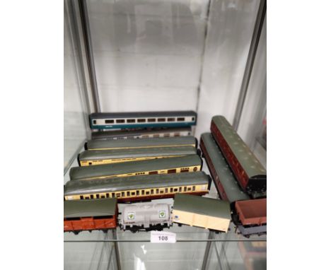 Shelf of 00 gauge coaches wagons etc .