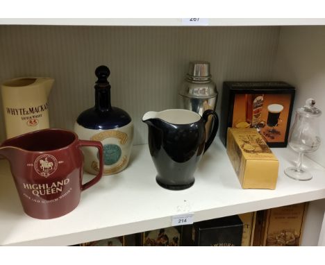 Shelf of whisky pub jugs and other whisky related items . 