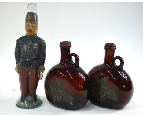 A 19th century wine bottle moulded in the form of a French soldier, enamelled red and blue uniform, to/w two Franconian Bocks