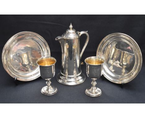 A cased Victorian silver communion set, comprising two chalices, two patens and claret jug, the chalices having slightly flar