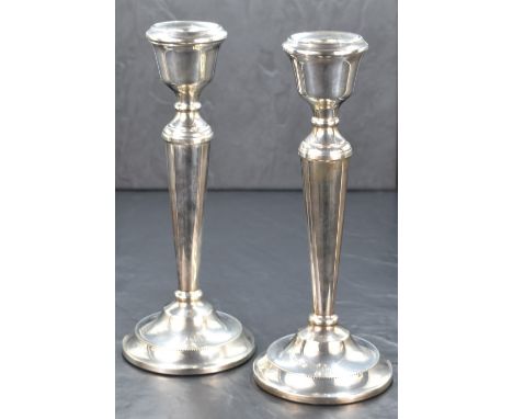 A pair of Elizabeth II candlesticks, of traditional form having moulded sconces, knopped stems on fluted bodies and raised on