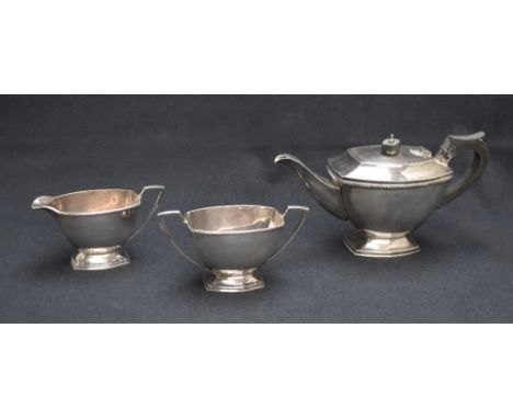 An Elizabeth II silver three-piece tea set comprising a tea pot, sugar and cream, all of rectangular form, having gadrooned r