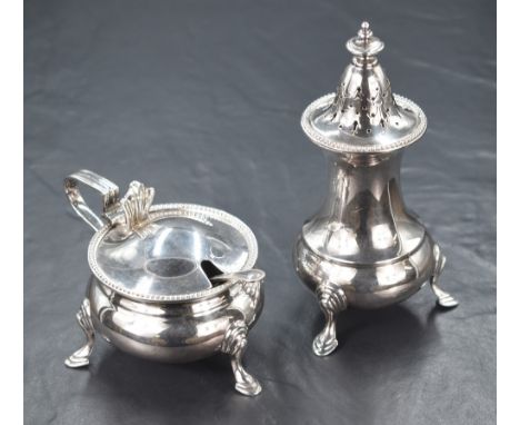 A George V silver sugar caster and condiment pot with spoon, of baluster form having bead thread to all with step moulded, ra