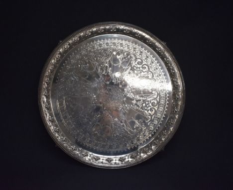 A large and impressive Victorian silver salver, of circular form having a bead thread rim with embossed and engraved conformi