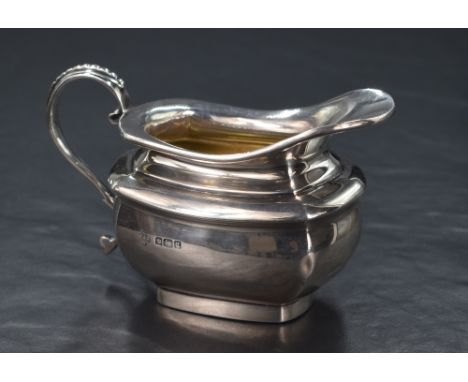 An Edwardian silver sauce boat, of rectangular form having a flared rim, shallow spout opposed by a bead thread s-curve handl