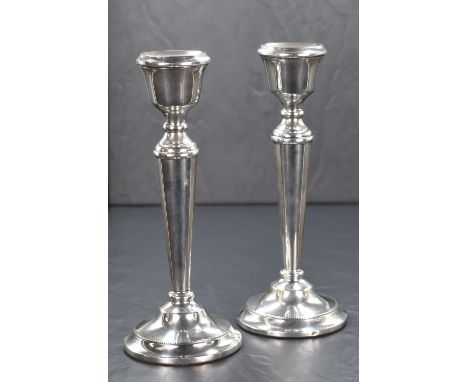 A pair of Elizabeth II silver candlesticks, of traditional form having moulded sconces with knopped stems on fluted bodies, r