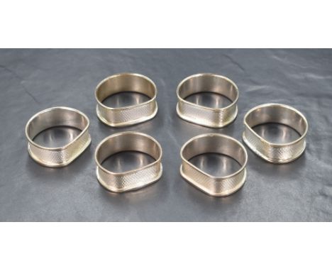 A set of six Elizabeth II silver napkin rings, having engine turned decoration and vacant rectangular cartouches, marks for B