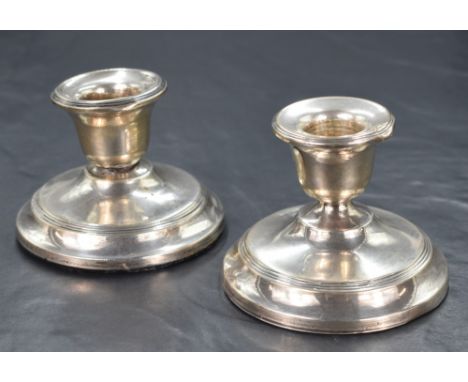 A pair of George V silver stout candlesticks, of traditional form having step moulding decoration, marks for Chester 1912, 19