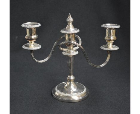 A silver plated two-branch candlestick, of turned and circular form, the central columns flame finial top issuing two twisted
