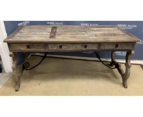 An Oka stained pine writing table in the 18th Century Spanish taste the plank top over three drawers on scroll work decorated