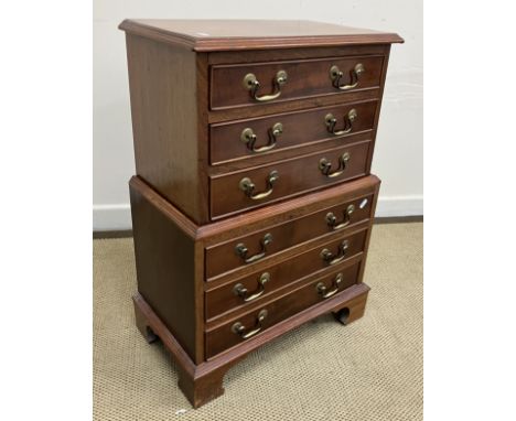 A 20th Century mahogany miniature chest on chest in the George III style, the plain top with applied moulded edge over six lo