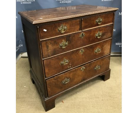 An 18th Century and later walnut and oak chest, the top with applied moulded edge over two short and three long graduated dra