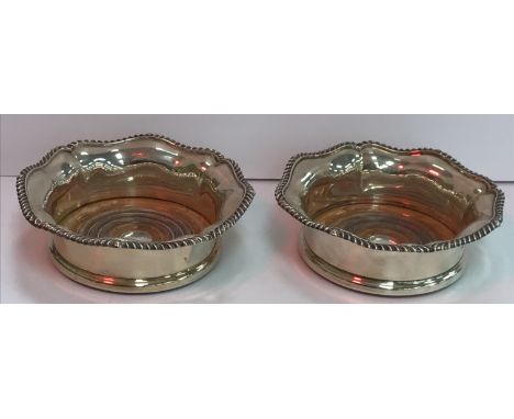 A pair of Victorian silver wine coasters with wooden bases, the flared rim with gadrooned edge and engraved initials to the c