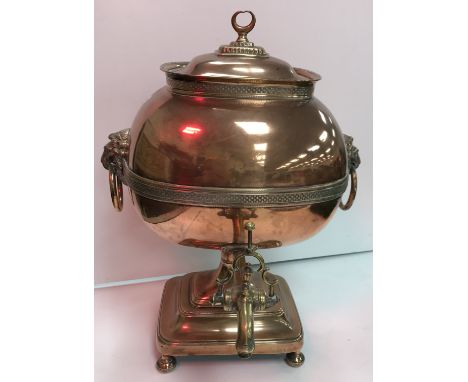 A 19th Century copper samovar with lion mask ring handles and brass tap 43 cm high, a pair of plated on copper table candlest