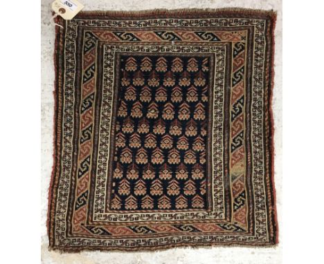 A vintage Soumac rug, the central panel set with repeating designs on a dark blue ground within a stepped scrolling geometric