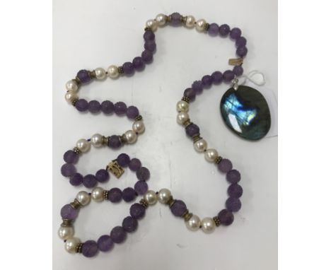 A Chinese pearl and carved amethyst court type bead necklace with 9 carat gold mounts/clasp 40 cm long together with a fluori