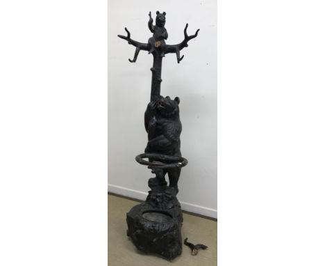 A 19th Century Black Forest carved and stained wood stick stand in the form of a bear clutching a tree with cub above raised 