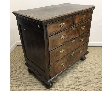 An 18th Century and later walnut chest, the oak top with moulded edge over two short and three long graduated drawers with br