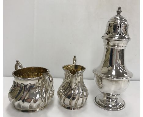 A Victorian silver milk jug and matching sugar basin with wrythen decoration, raised on circular flared feet (Birmingham 1870