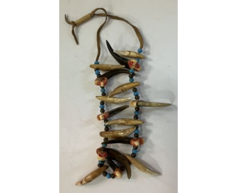 A Native American Piegan or Cheyenne Braves necklace made from Grisly Bear claws and teeth interspersed by brass and turquois