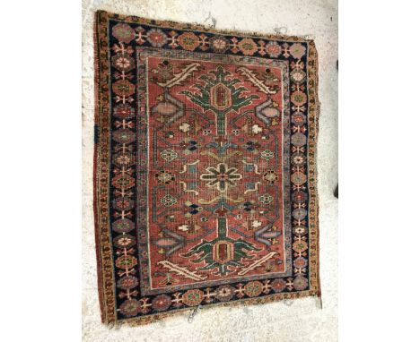 A Persian rug, the central panel set with foliate and flower head design on a red ground within a stepped pale blue, dark blu