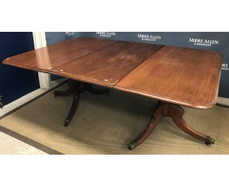 A late Regency mahogany dining table, the rounded rectangular top with moulded edge and single extra leaf raised on turned an