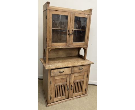 A 19th Century Continental pine dresser, the three quarter gallery top over two glazed doors and recess with inverted love he