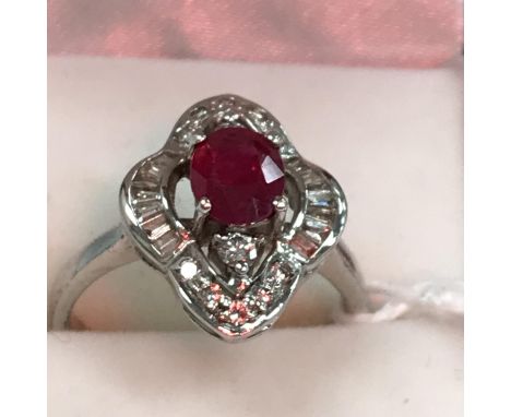 An 18 carat white gold mounted diamond and ruby dress ring, the centre stone approx 0.5 carat, size L, 4 g