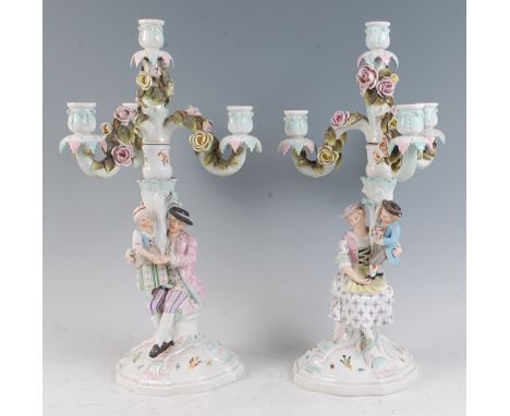 A pair of late 19th century Sitzendorf porcelain four-light candelabra, each modelled as a seated gallant and maiden with att