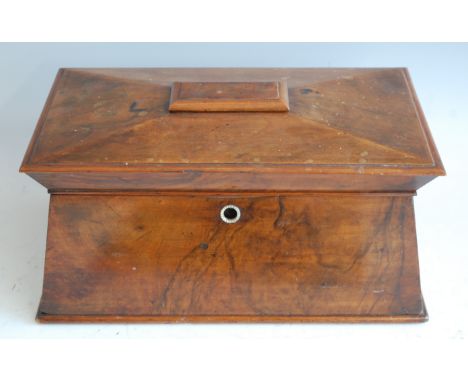 *A circa 1830 walnut tea caddy, of sarcophagus form, the hinged lid opening to reveal fitted interior, having central associa