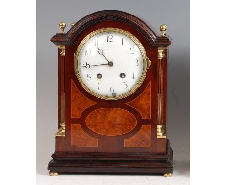 An Edwardian mahogany and walnut inlaid dome-top bracket clock, having an unsigned convex white enamel dial, twin winding hol