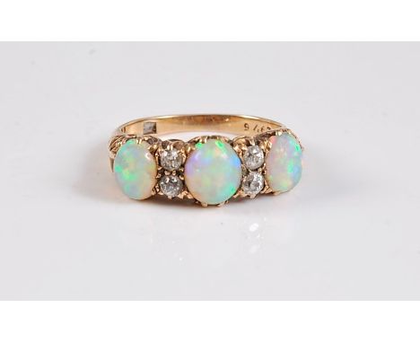 An 18ct three stone opal and diamond ring, the three oval opal cabochons interspaced with two small round diamonds, total wei