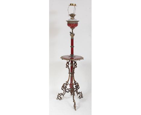 A Victorian gilt metal and enamel telescopic lamp standard, having a brass burner over thumb-cut glass font, all in a fluted 