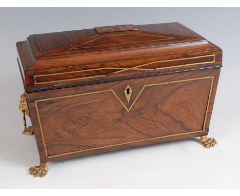 A Regency rosewood and brass inlaid tea caddy, of sarcophagus form, having fitted interior with centre cut glass mixing bowl 