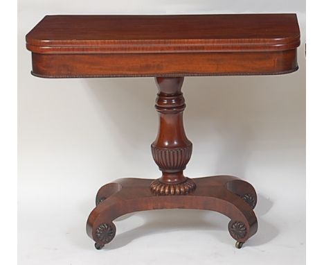 A William IV mahogany card table, the D-shaped fold-over top revealing a baize lined playing surface, on fluted urn shaped co