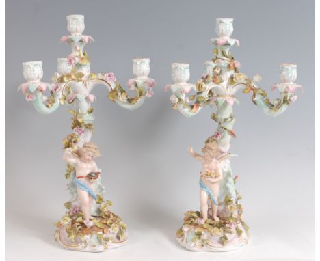A pair of circa 1900 German porcelain four light candelabra, each modelled as a floral encrusted treestump with single standi