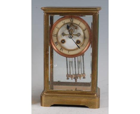 A circa 1900 brass cased four glass mantel clock, having white enamel chapter ring (heavily crazed), visible escapement for a