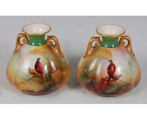 *A pair of Royal Worcester twin handled porcelain vases, of squat melon form, each hand-painted with a pheasant amidst landsc