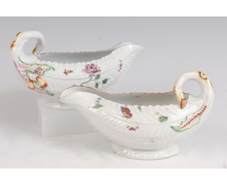 A pair of mid-18th century Worcester porcelain cabbage leaf moulded sauceboats, each with stalk handle and polychrome painted