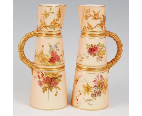 *A near-pair of Royal Worcester porcelain blush ivory ewers, each of conical form, hand-painted with floral sprays, having gi