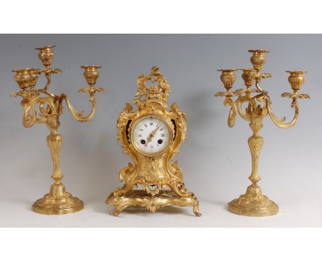 A Rococo Revival gilt metal three-piece clock garniture, the clock of balloon shape, the swept case adorned with acanthus lea