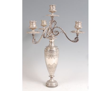 A Victorian silver four light candelabrum, the candle holders each modelled as half-reeded pedestal urns with detachable scon