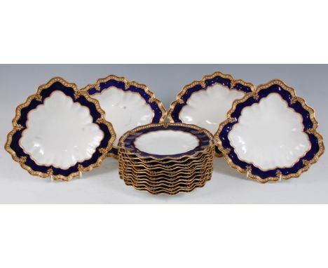 *A Royal Crown Derby part dessert service, each piece on a white ground within a cobalt blue border heightened in gilt, with 