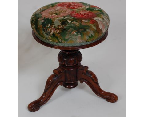 *A Victorian rosewood pedestal piano stool, the circular floral embroidered stuffover revolving seat on a carved column and a