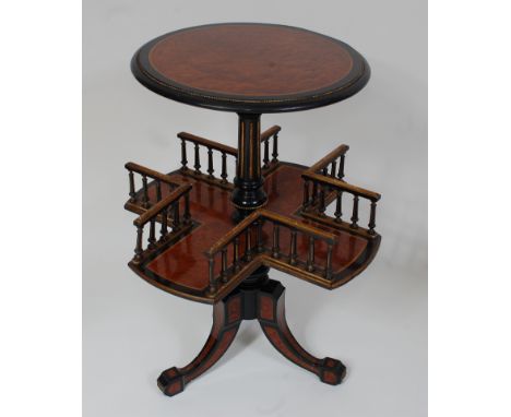 *A Victorian amboyna, ebonised, and parcel gilt book table, the circular top on a turned column above spindled gallery, on sp