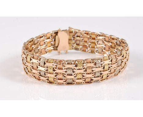 A tri-coloured gold bracelet, the alternating bands of tri-coloured textured gold interwoven with short oval inks, with conce