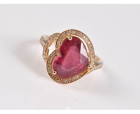 A 14k heart shaped ruby and diamond ring, the heart shaped ruby, set at 90 degrees to the band, surrounded by small round dia