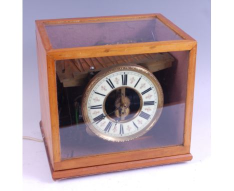 An electric 'rolling ball' clock, apparently made-up, the whole housed in glazed wooden case, the clock with white enamel dia